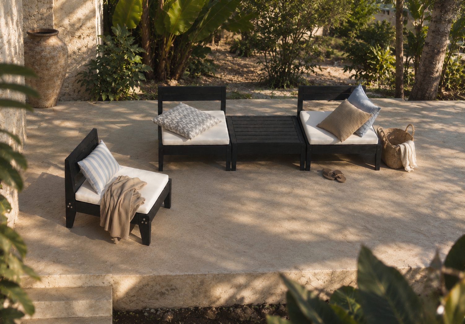 Three Lounge Chairs and a low table on a stone terrace in a garden